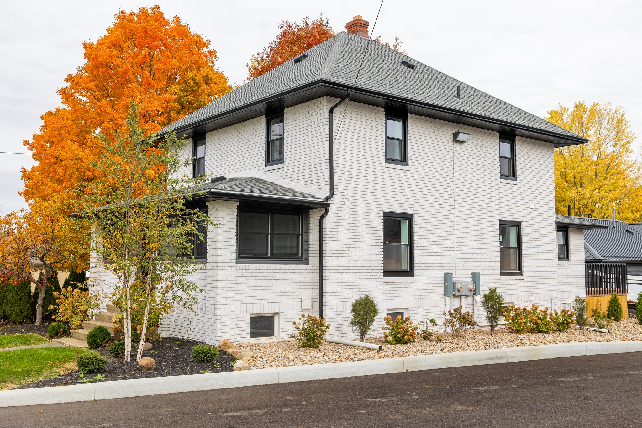 Exterior home remodel in Bartonville, TX featuring painted brick, new windows, and modern exterior upgrades