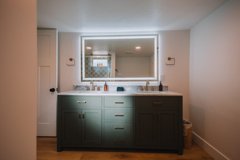 Master bathroom remodel in Denton, TX with a double vanity, marble countertop, and backlit mirror