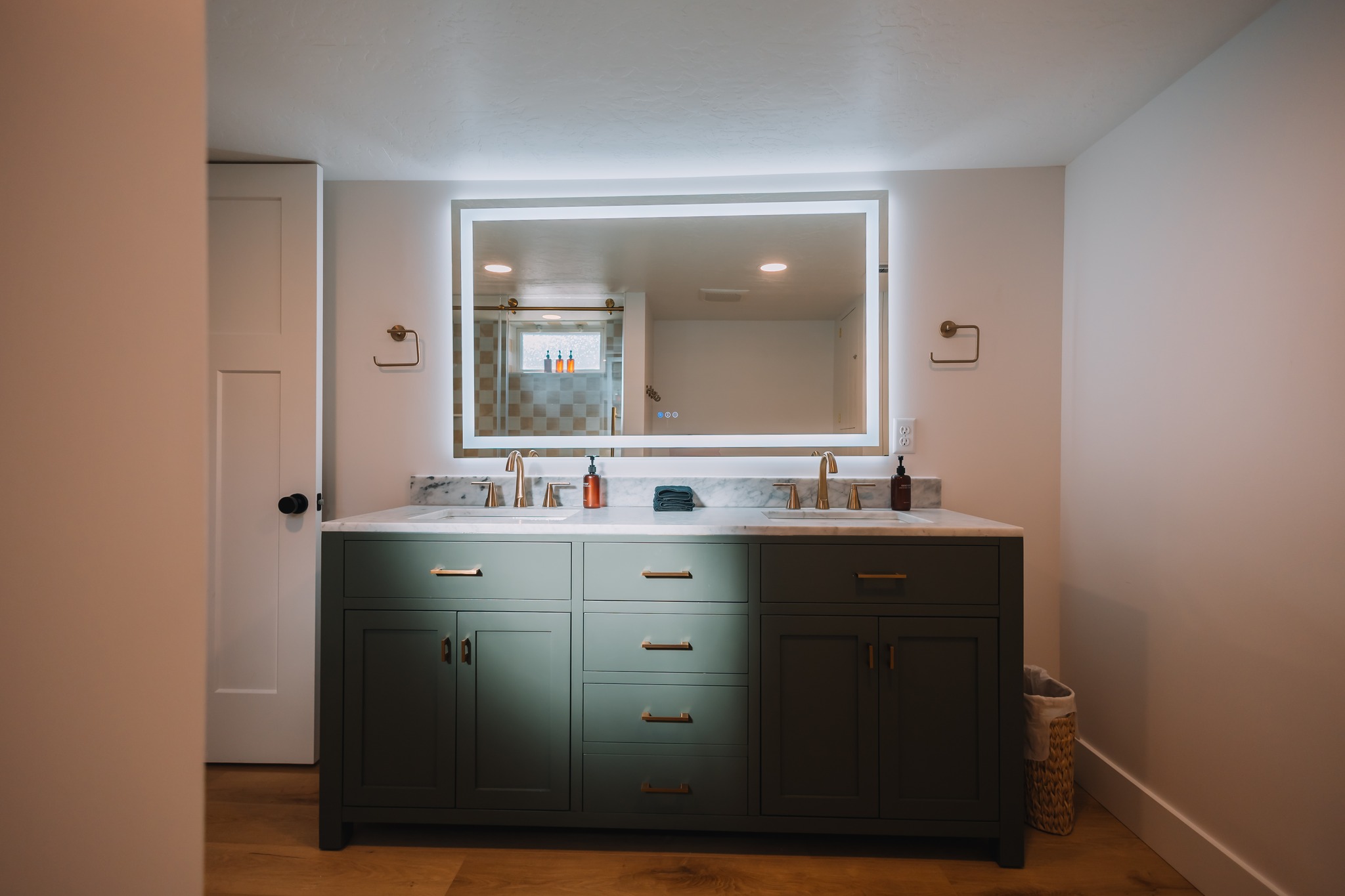 Master bathroom remodel in Denton, TX with a double vanity, marble countertop, and backlit mirror