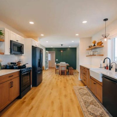 Spacious Fort Worth, TX kitchen with white countertops, wooden cabinets, open shelves, black appliances, bright lighting, and a welcoming modern farmhouse feel